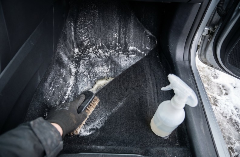 Водительская зона автомобиля с видимыми белыми солевыми разводами на ковролине